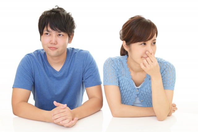 鼻をつまんでいる女性とよそ見をする男性