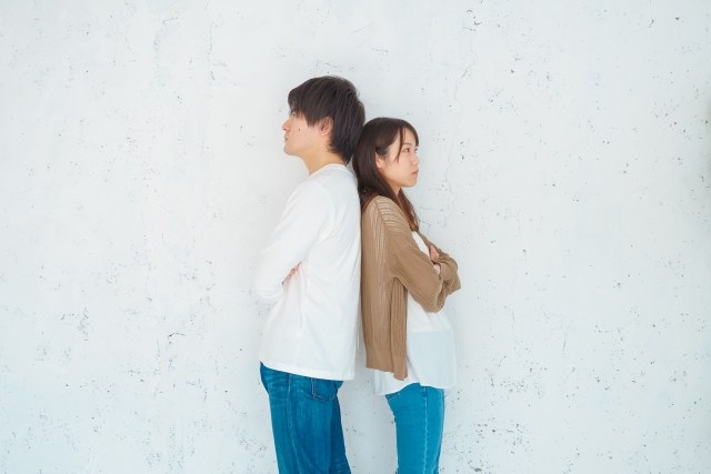 背中合わせに立つ男女